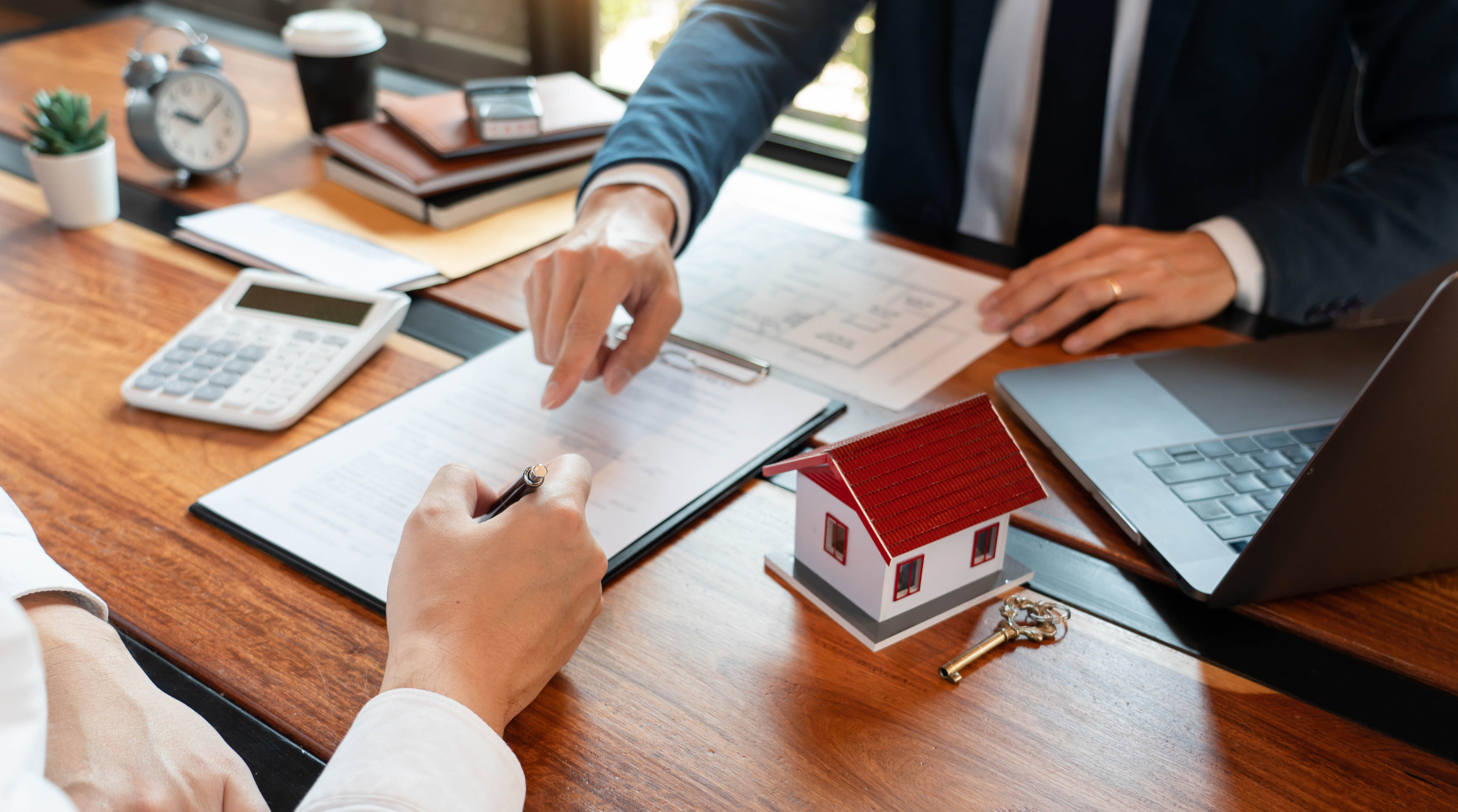 Homebuyer signing documents for a mortgage to purchase an auction property