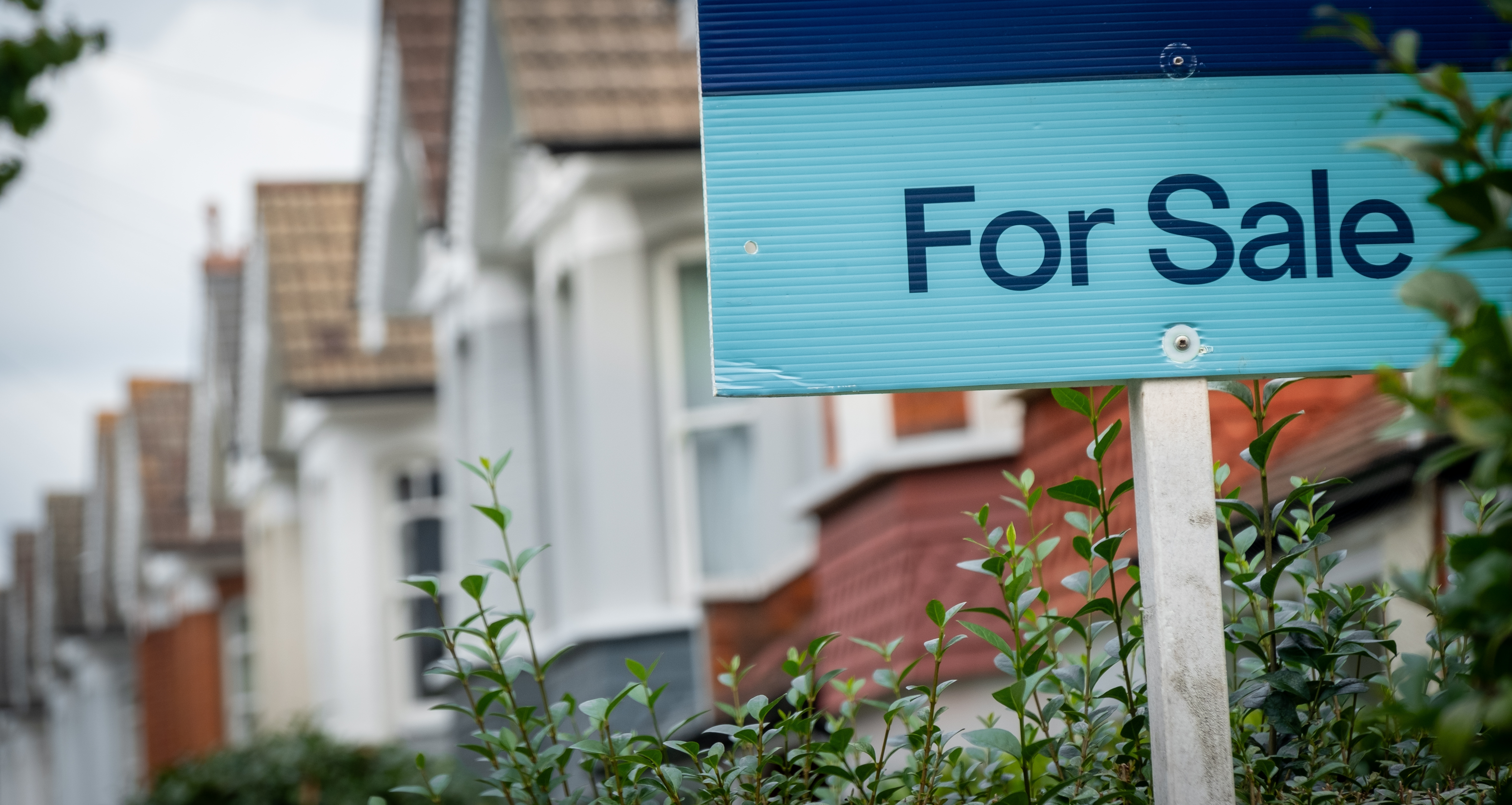 For sale sign on a terraced street of houses