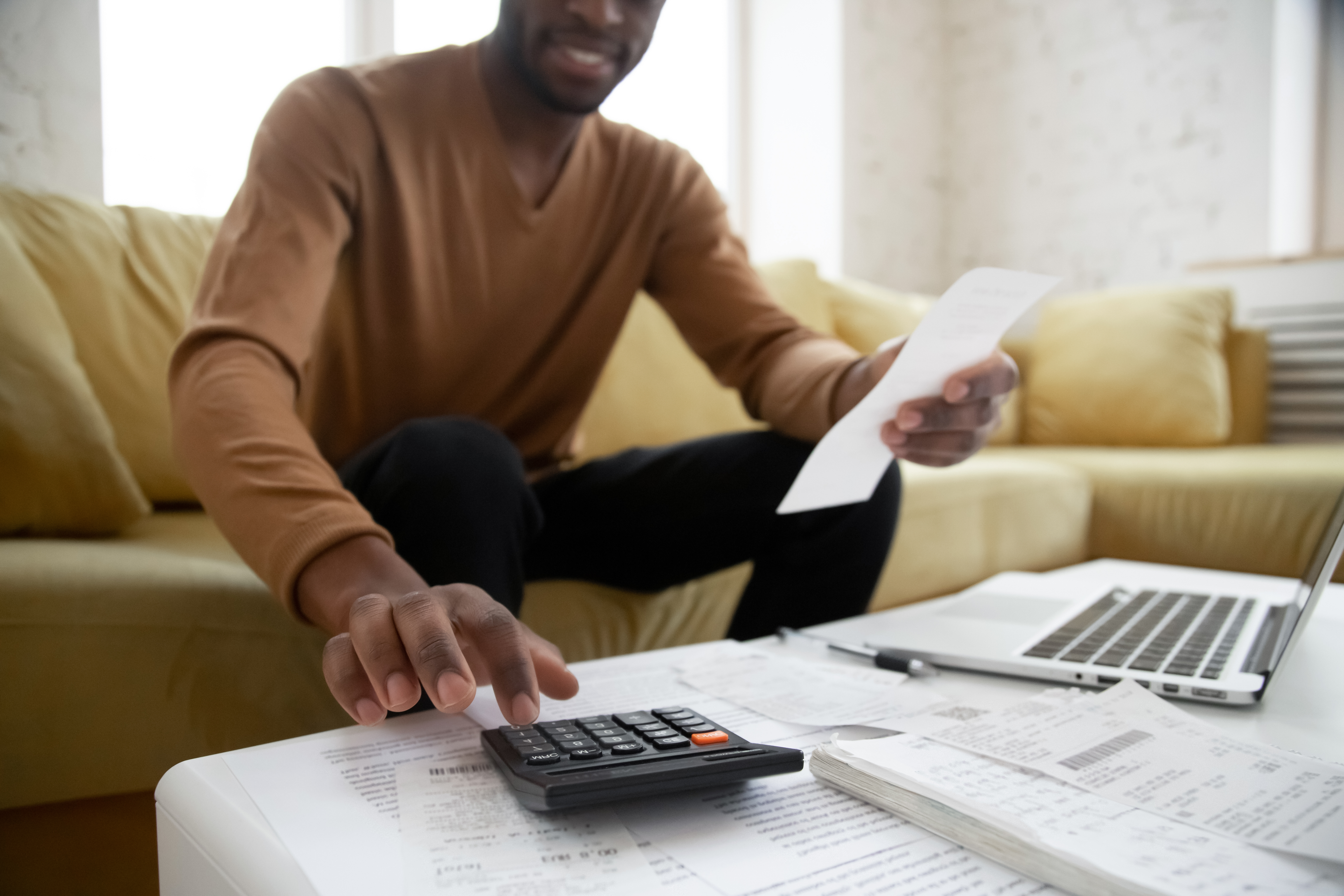 A man doing calculations in front of a laptop